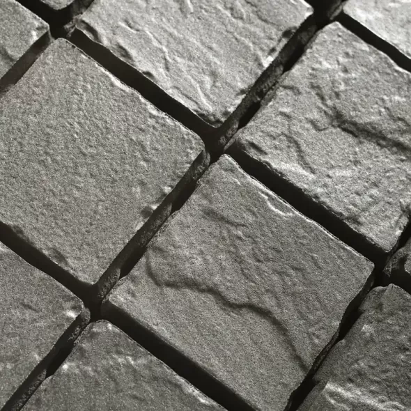Juodo bazalto akmens imitacijos betoninių trinkelių paviršius iš arti